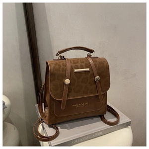 Detail of vintage leopard print flap and gold rivets on a brown large capacity backpack
