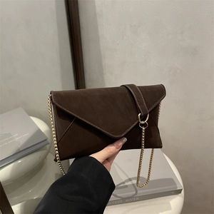 Dunkelbraune Umschlagtasche mit goldenem Ringschloss und feinem Ketten-Schultergurt