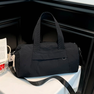 Minimalist black nylon fitness travel bag with adjustable straps and front zipper pocket