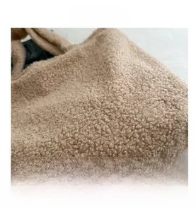 Close-up detail of soft fluffy faux fur texture on a large beige tote handbag