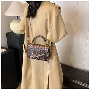 Detail der Leopard Handtasche mit goldener Metalleinfassung und Schultergurt