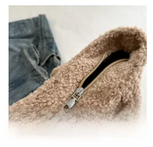 Close-up of smooth metal zipper and plush beige fleece texture on large tote bag