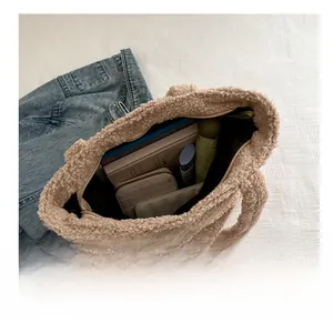 Detail view of spacious beige plush tote bag showing capacity for laptop and umbrella