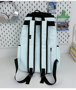 Detail view of light blue drawstring backpack with adjustable straps and anti-theft zipper pocket