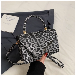 Detail der Handtasche mit Leopardenmuster, goldenem Metallrand und passendem Schultergurt
