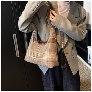 Detail of the vintage plaid hobo bag featuring dark brown trim and a stylish shoulder strap