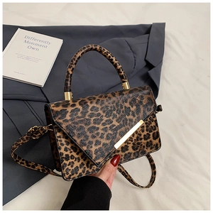Detailaufnahme der Leoparden-Handtasche mit goldenem Metallverschluss auf Blazer