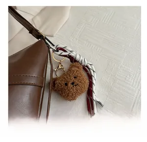Détail du charme d'ours en peluche marron et corde tissée sur le sac vintage
