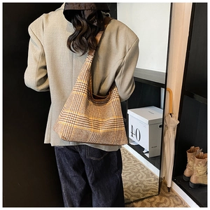 Classic plaid hobo shoulder bag styled with an autumn outfit in a cozy indoor setting