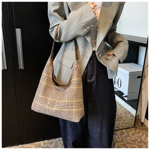 Side view of model wearing a vintage houndstooth tote bag with leather shoulder straps