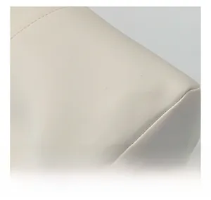 Close-up of the textured beige faux leather fabric and precision stitching on the tote bag