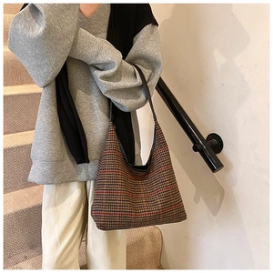 Close-up of vintage houndstooth fabric texture on a stylish half-moon hobo bag