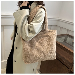 Detail view of large beige plush faux fur tote bag showing soft texture and shoulder fit