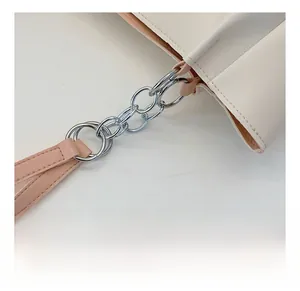 Detailed close-up of premium leather tote bag with silver chain links and pink strap