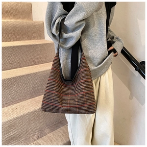 Detail of vintage houndstooth shoulder bag in brown and black on a female model