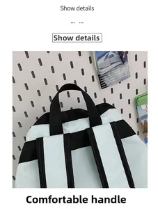 Detail of reinforced top handle and black woven straps on a durable nylon backpack