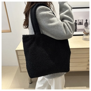 Close-up of fluffy black plush tote bag texture with high-density faux lamb wool fabric