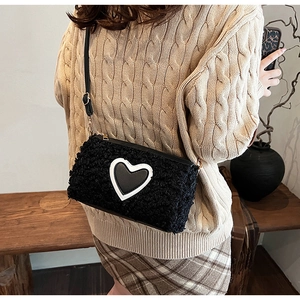 Borsa a tracolla chic in peluche nera con dettaglio a cuore, abbinata a un maglione