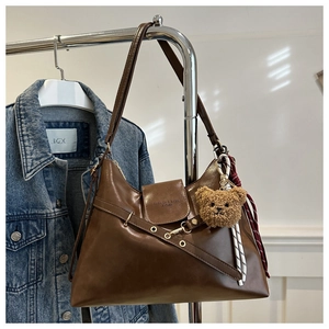 Détail du sac bandoulière marron en similicuir avec pendentif ours et breloque en corde