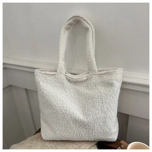 Close-up of white plush fleece tote bag texture on wooden table with cozy items