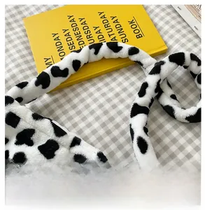 Detail of soft plush shoulder strap featuring a stylish black and white cow print texture