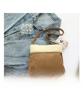 Detail showing brown suede shoulder bag with white fleece trim and cute bear charm