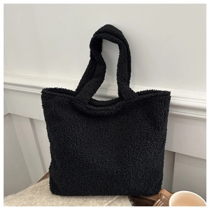 Detailed view of black fluffy fleece tote bag texture with minimalist shoulder straps