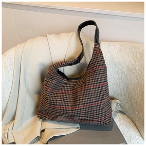 Close-up of the woven houndstooth texture and leather strap on this large tote bag