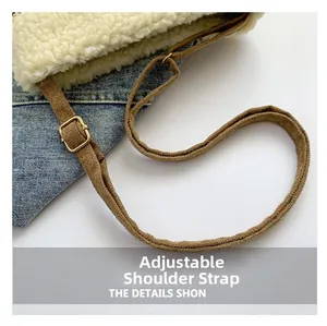 Detail view of adjustable brown suede shoulder strap on a plush denim crossbody bag