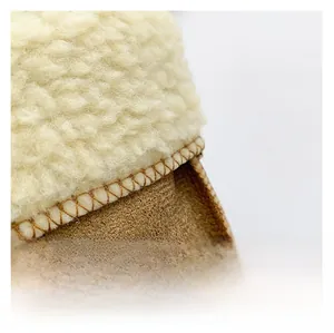 Detailed close-up showing thick faux shearling lining and brown suede fabric with quilting
