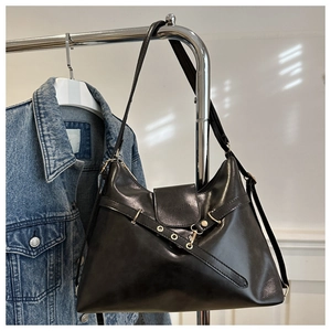 Détail du sac à main en cuir noir mat avec œillets métalliques et texte gravé élégant