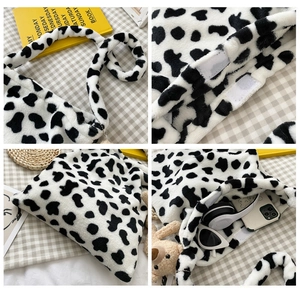 Detail view of cow print plush bag showing Velcro closure and spacious interior capacity