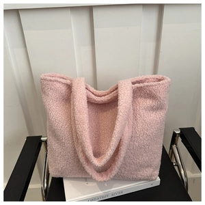 Detail view of the soft fluffy texture and wide plush shoulder straps of the pink tote bag