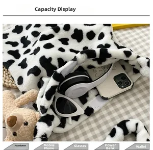 Macro detail showing large capacity of the cow print plush handbag with daily essentials