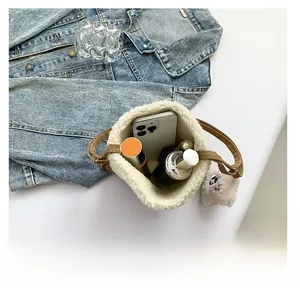 Detail showing plush bucket bag capacity with smartphone, perfume, and lipstick inside