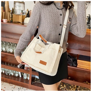 Detail of cream corduroy tote bag with leather straps and adjustable shoulder strap