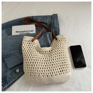 Detail der gestrickten Netztasche mit braunen Lederriemen und gewebter Textur