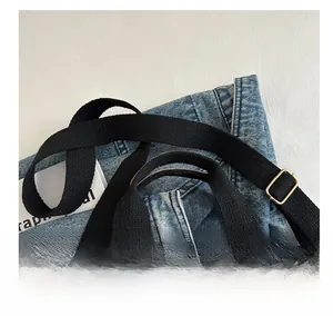 Detail of adjustable black canvas strap and vertical stripes on this tote bag
