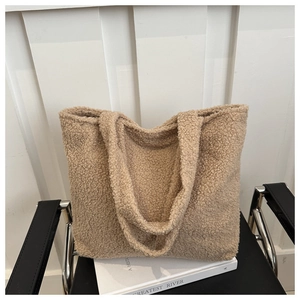 Close-up of soft khaki plush tote bag with textured fleece surface on a leather chair