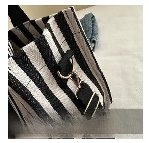 Detailed macro view of the striped canvas tote with high-quality golden metal hooks