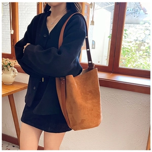 Detailed macro view of the vintage brown suede texture on the large bucket shoulder bag