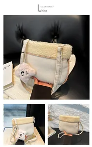 Close-up of white plush crossbody bag with brown stitching and a cute dog plush charm