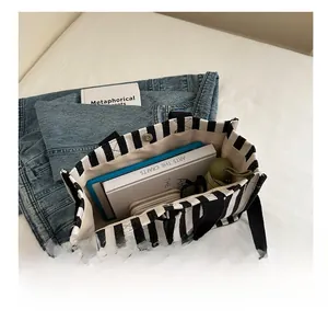 Spacious black and white striped canvas tote bag interior showing books and tablet