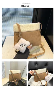 Detail of khaki faux suede crossbody bag with off-white fleece trim and a teddy charm