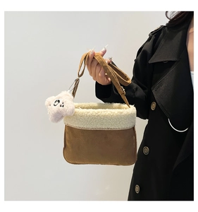 Detail of caramel suede bag with faux shearling trim and a white plush star charm