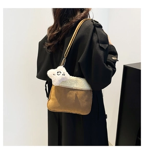 Brown plush crossbody bag with white shearling trim and star charm shown on a model