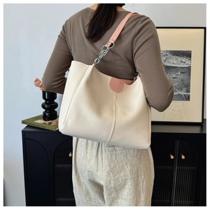Detailed view of the large ivory tote bag featuring pink straps and silver hardware