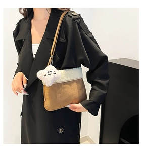 Detail of plush winter crossbody bag with white shearling trim and star charm accessory