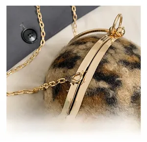 Détail du sac boule en peluche léopard avec monture en métal doré de haute qualité et chaîne