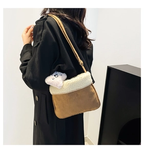Detail of vintage plush shoulder bag with white fleece trim and cute bear charm